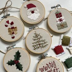 embroidered christmas ornament kits displayed on white surface with ribbon and ornaments around them