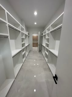 an empty walk - in closet with white shelving and no one sitting on the floor