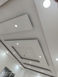 an empty room with white ceiling and lights on the ceiling is pictured in this image