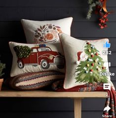 two decorative pillows on a bench with christmas tree and firetruck in the background