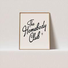 the homeboy club logo on a white wall above a black and white framed photograph