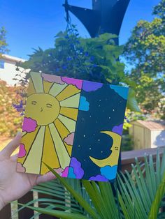 someone is holding up a card with the sun and moon on it