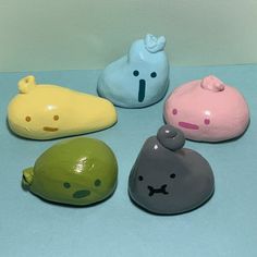 five small ceramic animals sitting next to each other on a blue counter top with white walls behind them