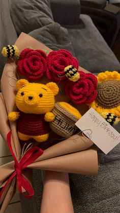 a person holding a bunch of knitted teddy bears and flowers in their hands with a sign that says happy valentine's day