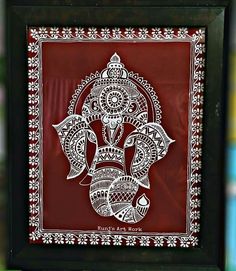 an intricately designed paper cut art depicting the head of a hindu god in red and white