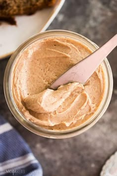 a spoon in a jar filled with peanut butter