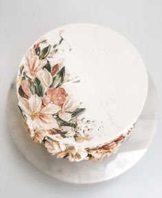 a cake decorated with flowers and leaves on a plate