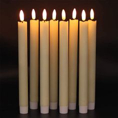 five lit candles are lined up in a row