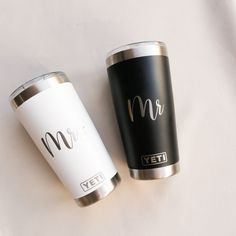 two yeti cups sitting next to each other on top of a white tablecloth