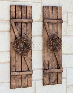 two wooden shutters that have wreaths on them