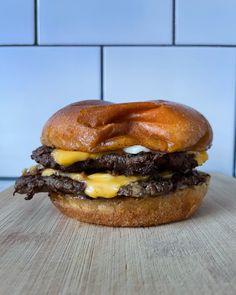 a cheeseburger is sitting on a wooden table