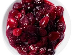 a white bowl filled with cherries covered in sauce