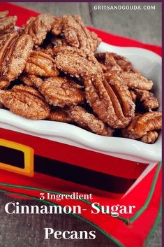 a white bowl filled with cinnamon - sugar pecans on top of a red tray