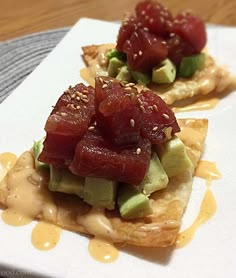 two waffles topped with fruit and sauce on top of a white square plate