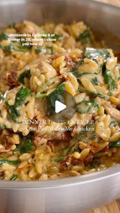 a pan filled with pasta and vegetables on top of a wooden table