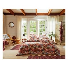 a bed room with a neatly made bed next to a window and rugs on the floor