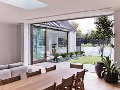 a dining room table and couches in front of a sliding glass door