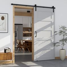 an open door leading to a kitchen and dining room area with potted plant in the corner