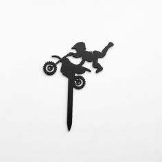 a paper cut out of a person riding a bike on a long stick with wheels