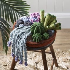 a crocheted cactus sits on top of a stool