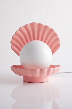 an egg is sitting in a shell shaped bowl