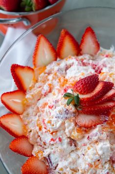 a bowl filled with strawberries on top of a table next to another bowl full of strawberries