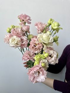 a woman is holding a bouquet of flowers