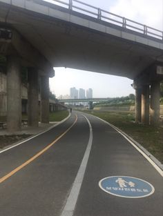 an empty road with a bridge in the background