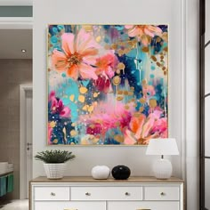 an abstract painting hangs on the wall above a white dresser and sideboard in a modern living room