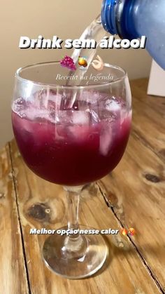 a glass filled with liquid sitting on top of a wooden table