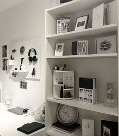 a white desk topped with a clock and lots of books