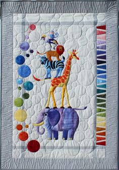 a quilted wall hanging with an animal and giraffe on it's side