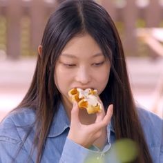 a young woman eating food with her hands