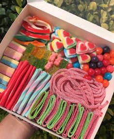 a box filled with lots of different colored candies and lollipops in it