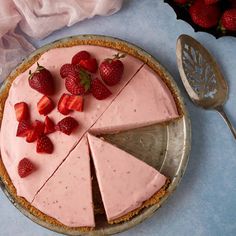 there is a pie with strawberries on it and a spoon next to the pie