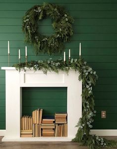 a fireplace decorated with greenery and candles