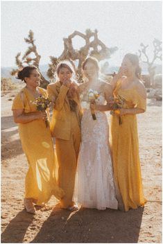 four bridesmaids in yellow dresses are posing for a photo with their bouquets