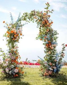 an arch made out of flowers in the grass