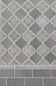 a close up view of a white and grey tile pattern on a wall or floor