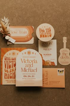 an assortment of wedding stationery items on a brown background with orange and white accents