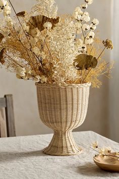 a vase filled with dried flowers on top of a table