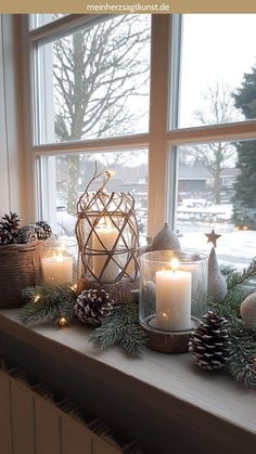 a window sill filled with candles and pine cones