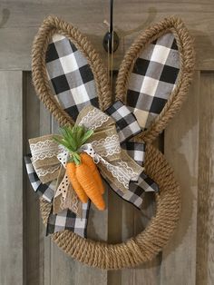 a door hanger decorated with an easter bunny's head and two carrots