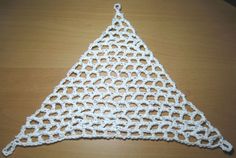 a crocheted triangle sitting on top of a wooden table