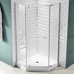 a corner shower stall in a white tiled bathroom