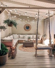 an outdoor living area with wicker furniture and string lights