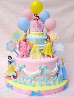 a birthday cake with princess figures on it