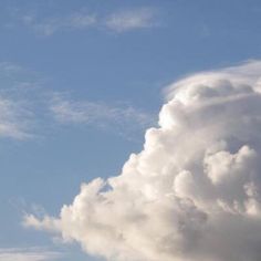 the airplane is flying high in the sky with clouds behind it and one plane on the ground