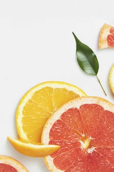 slices of grapefruit, orange and lemon on a white surface