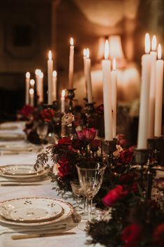 the table is set with candles and plates